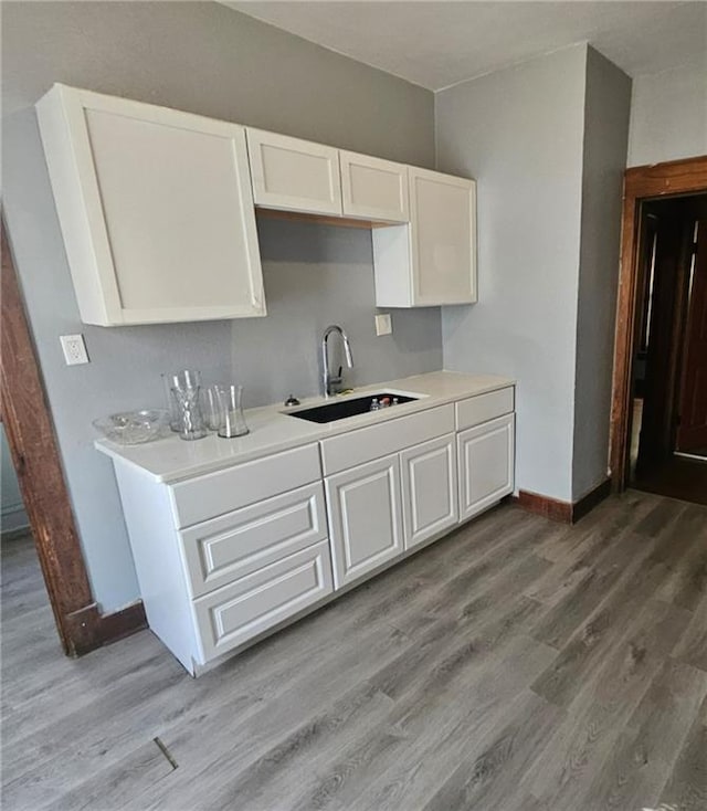 kitchen featuring sink, white cabinetry, and hardwood / wood-style floors