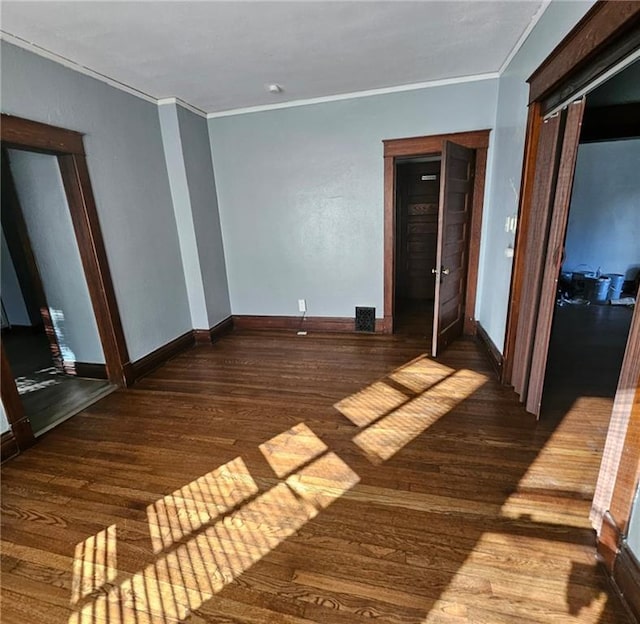 spare room featuring crown molding and dark hardwood / wood-style floors