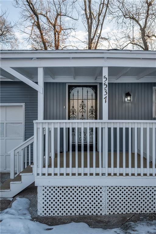 snow covered property entrance featuring covered porch