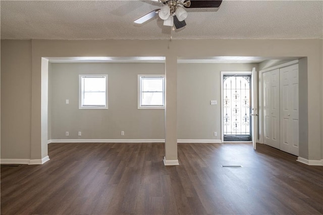 interior space with ceiling fan, dark hardwood / wood-style flooring, and a textured ceiling