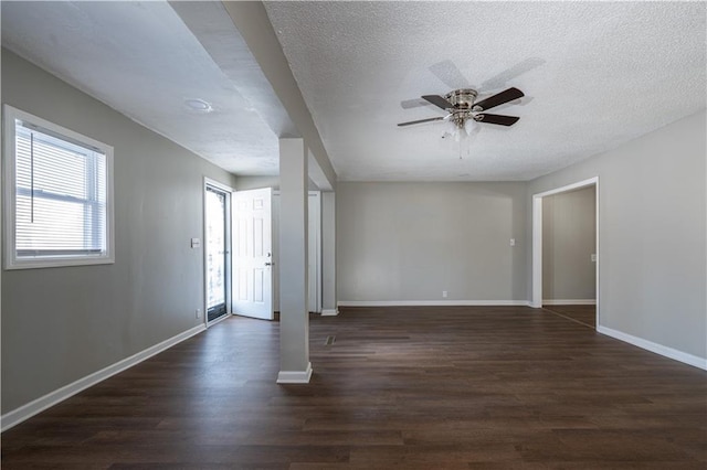 spare room with ceiling fan, dark wood-type flooring, and a textured ceiling