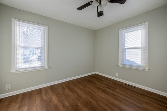 spare room featuring ceiling fan and dark wood-type flooring