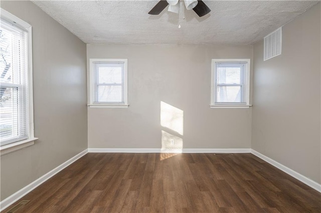 empty room with ceiling fan, a textured ceiling, and dark hardwood / wood-style floors