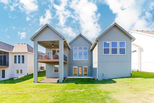 back of house with ceiling fan and a lawn