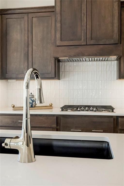 kitchen with decorative backsplash, premium range hood, and dark brown cabinets