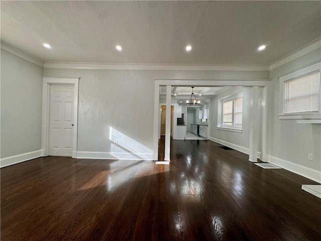 unfurnished living room with dark hardwood / wood-style flooring, ornamental molding, and a notable chandelier