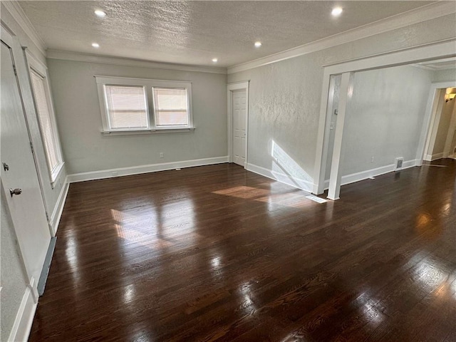 spare room with a textured ceiling, ornamental molding, and dark hardwood / wood-style floors