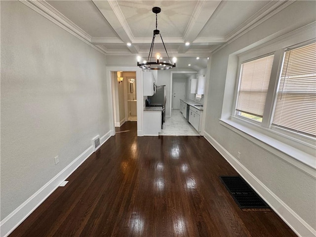 unfurnished dining area featuring beam ceiling, wood-type flooring, crown molding, an inviting chandelier, and coffered ceiling