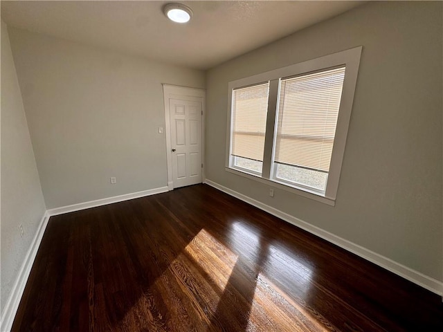 unfurnished room with dark hardwood / wood-style flooring