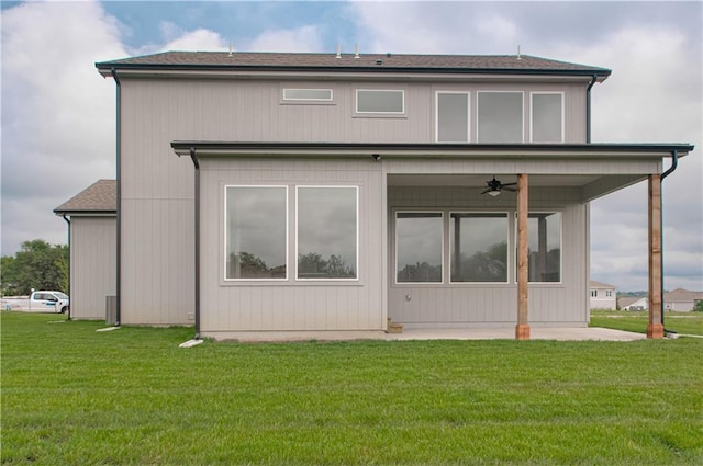 rear view of house with ceiling fan, a patio area, and a lawn