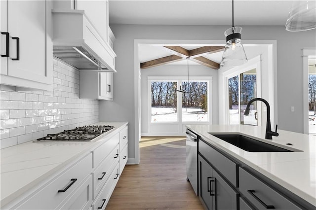 kitchen featuring gray cabinets, hanging light fixtures, white cabinetry, a sink, and premium range hood