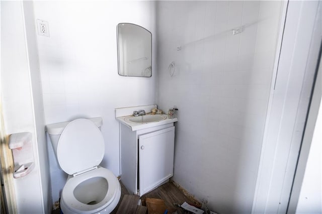 bathroom with vanity, wood-type flooring, and toilet