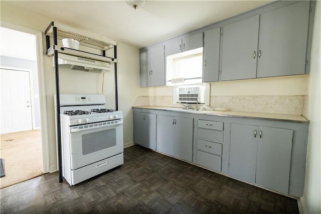 kitchen with dark parquet flooring, sink, gray cabinets, and white gas range oven