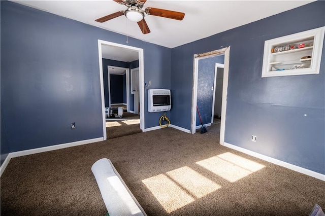 unfurnished bedroom featuring heating unit, baseboards, carpet, and ceiling fan