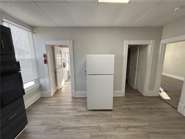 kitchen with oven, white fridge, and light wood-type flooring