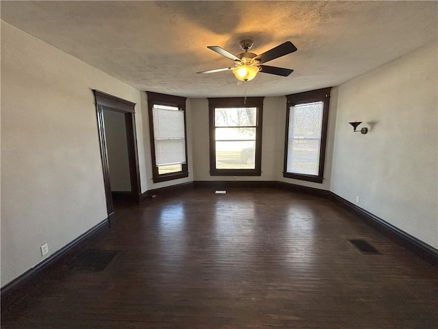 unfurnished room featuring a textured ceiling, ceiling fan, and dark hardwood / wood-style flooring