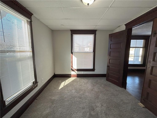 spare room with dark carpet and a drop ceiling