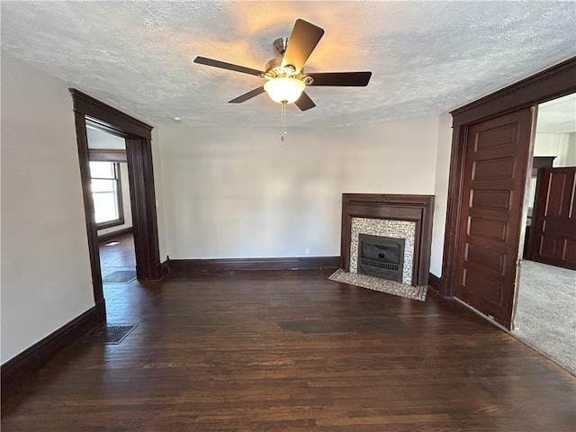 unfurnished living room featuring a textured ceiling, ceiling fan, and dark wood-type flooring