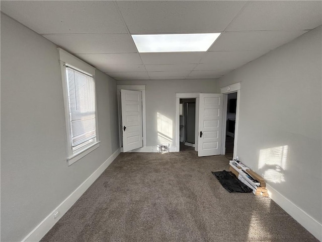 unfurnished bedroom featuring carpet floors, a paneled ceiling, and baseboard heating