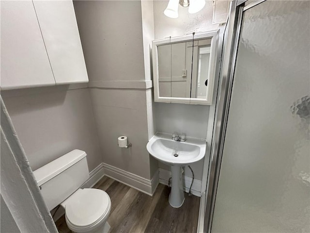 bathroom featuring toilet and wood-type flooring