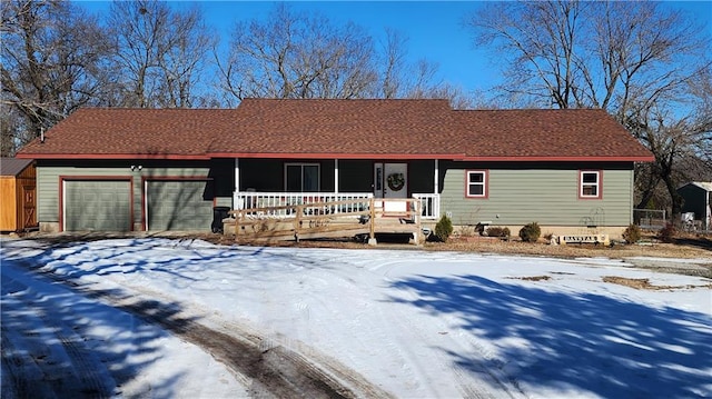 ranch-style house featuring covered porch and a garage