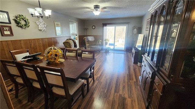 dining room with a textured ceiling, dark hardwood / wood-style flooring, and ceiling fan with notable chandelier