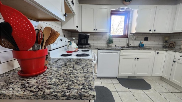 kitchen featuring decorative backsplash, sink, white appliances, white cabinetry, and light tile patterned floors