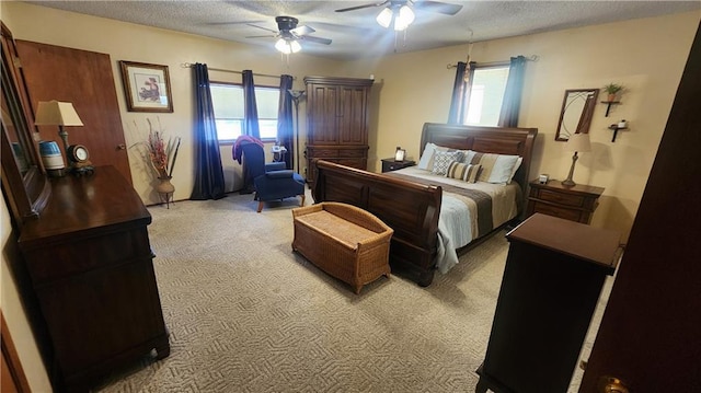 bedroom featuring ceiling fan, a textured ceiling, and light carpet