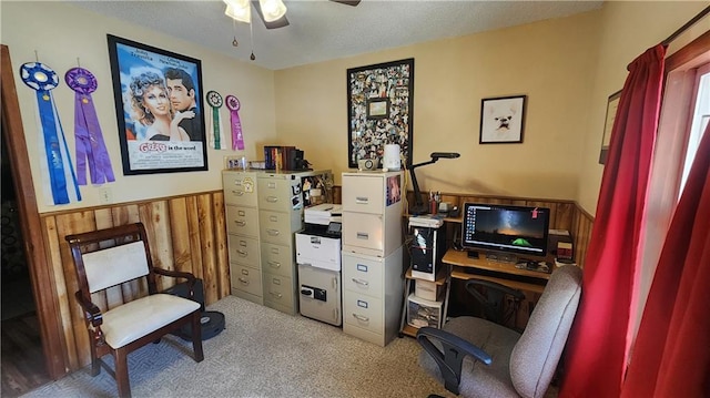 sitting room with ceiling fan, carpet, and wooden walls