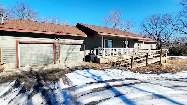 ranch-style house featuring a garage and covered porch