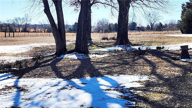 yard layered in snow with a rural view