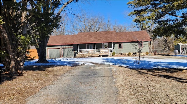 single story home featuring covered porch and a garage