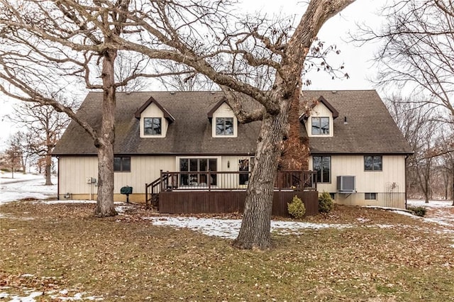 snow covered back of property with a wooden deck