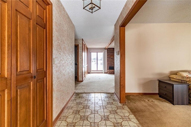 hall featuring light colored carpet and a textured ceiling