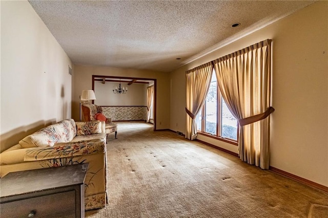 unfurnished room featuring a textured ceiling, carpet flooring, and a chandelier