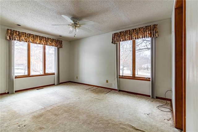 unfurnished room with ceiling fan, light colored carpet, and a textured ceiling