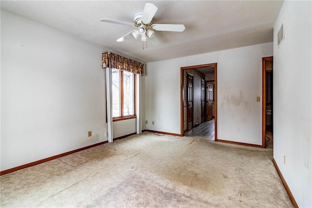 empty room featuring ceiling fan and light carpet