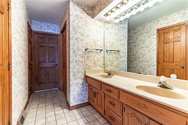 bathroom with a textured ceiling, tile patterned floors, and vanity