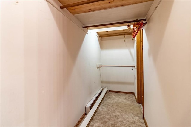 spacious closet featuring a baseboard radiator and light carpet