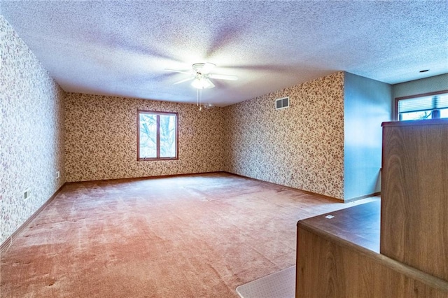 carpeted empty room featuring ceiling fan and a healthy amount of sunlight