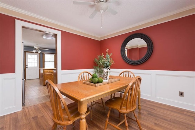 dining room with ceiling fan, wood-type flooring, and ornamental molding