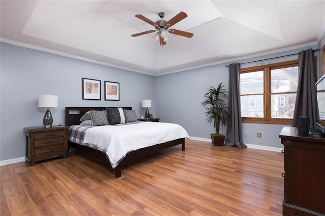 bedroom featuring ceiling fan, crown molding, and a tray ceiling