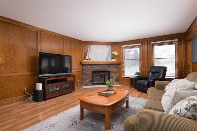 living room featuring hardwood / wood-style flooring, wood walls, and a fireplace