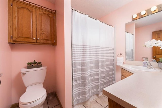 bathroom featuring toilet, vanity, and tile patterned flooring