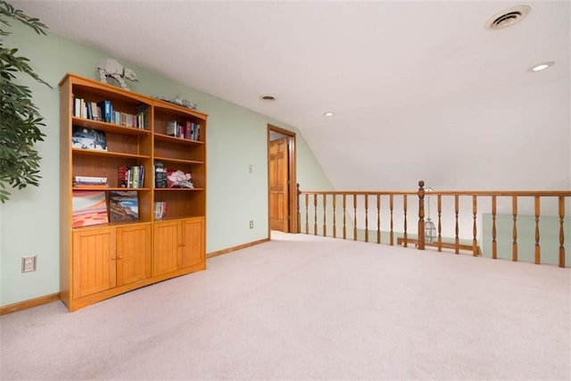 interior space with vaulted ceiling and light colored carpet