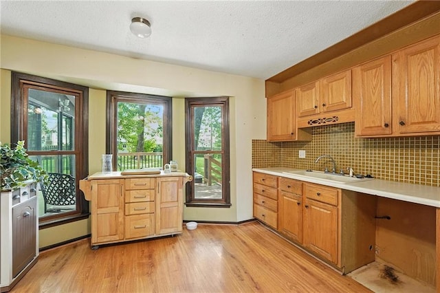 4722 Switzer Rd, Shawnee, KS 66203 - kitchen with light wood-style floors, light countertops, tasteful backsplash, and a textured ceiling
