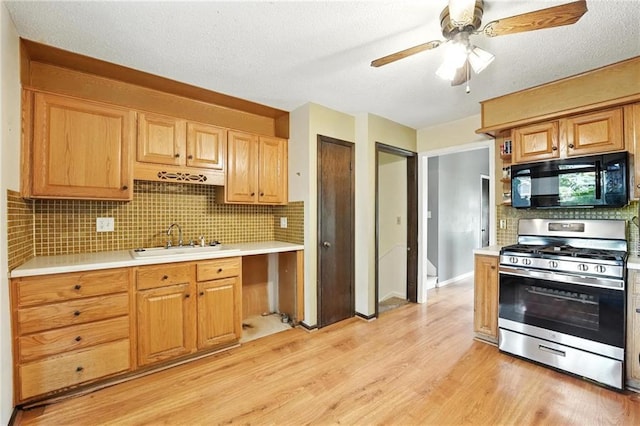 4722 Switzer Rd, Shawnee, KS 66203 - kitchen with gas range, black microwave, light wood finished floors, light countertops, and a ceiling fan