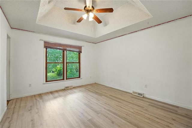 4722 Switzer Rd, Shawnee, KS 66203 - unfurnished room featuring a tray ceiling, wood finished floors, ceiling fan, and a textured ceiling