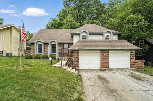 4722 Switzer Rd, Shawnee, KS 66203 - tri-level home with asphalt driveway, a front yard, brick siding, a garage, and roof with shingles