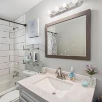 full bathroom featuring toilet, tiled shower / bath, and vanity